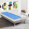 A mattress with a blue topper on a bed frame, in a room with artwork on the wall and a bookshelf. Produktbild-Vorschau