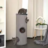 Three cats are interacting with a tall, cylindrical cat scratching tower in a room with curtains and a small table with a plant. Náhľad obrázku produktu
