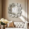 A decorative wall clock is mounted on a wall above a sofa, with a vase of flowers in the foreground. Anteprima dell’immagine prodotto