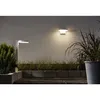 Outdoor lighting setup with a wall-mounted light and a path light, surrounded by plants and concrete blocks. Produktbild-Vorschau