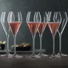 A set of six champagne glasses filled with pink champagne, arranged on a dark wooden surface against a dark gray background. Produktbild-Vorschau