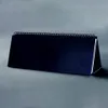 A dark blue desk calendar with a spiral binding is shown against a gray background. Podgląd zdjęcia produktu
