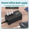 A black 12-port USB charging station is shown on a wooden desk, with multiple devices plugged in and charging. Náhled obrázku produktu