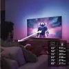A person is relaxing on a couch watching a large TV screen with ambient lighting. Voir les images du produit