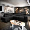 A modern living room with a large black sectional sofa and a unique coffee table. Produktbild-Vorschau