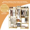 A bamboo clothing rack with clothes and storage boxes. Produktbild-Vorschau