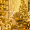 A festive indoor scene with a decorated Christmas tree, a reindeer figure, and gifts, all illuminated by warm string lights. Podgląd zdjęcia produktu