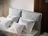 A close-up view of a bed with multiple pillows. Produktbild-Vorschau