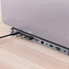 A close-up view of a laptop's side with a docking station attached, showing various ports and connected USB drives. Produktbild-Vorschau