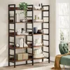 A tall, industrial-style bookshelf filled with decorative items and books, placed in a room next to a green tufted sofa. Podgląd zdjęcia produktu