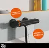 A black matte waterfall faucet in a bathroom setting, with water flowing. Text overlays highlight features. Náhled obrázku produktu