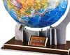 A close-up view of a 3D puzzle globe, showing a portion of the Earth with continents and oceans, mounted on a stand. A small plaque with the word "GLOBE" is visible on the base. Produktbild-Vorschau