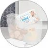 A package of wet wipes is placed on a child's potty training toilet. Produktbild-Vorschau