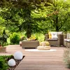 An outdoor patio scene with furniture, plants, and decorative spheres. Produktbild-Vorschau