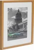 A framed black and white photograph of a building with cars in the foreground. Produktbild-Vorschau