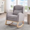 A gray rocking chair with wooden legs is placed on a rug in a room with a window in the background. Podgląd zdjęcia produktu