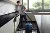 A man is vacuuming a kitchen countertop with a Bosch vacuum cleaner. Produktbild-Vorschau