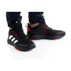 A pair of Adidas sneakers worn by a person. Podgląd zdjęcia produktu