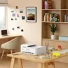 A home office setup with a printer on a desk, a chair, and shelves in the background. Podgląd zdjęcia produktu