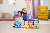 Two people, a young girl and a young woman, are sitting on the floor surrounded by several colorful stuffed bears. They are in a room with soft seating, a lamp, and a yellow armchair. Anteprima dell’immagine prodotto