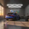 A blue car parked in a garage with hexagonal LED lights on the ceiling and a "master LED" logo on the wall. Podgląd zdjęcia produktu