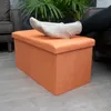 A person's feet in socks resting on an orange ottoman. Anteprima dell’immagine prodotto