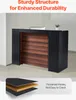 A reception desk with a wooden front panel and black sides, shown in an office setting. A small plant and a computer monitor are on top. Anteprima dell’immagine prodotto