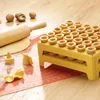 A baking setup with a rolling pin, dough, and a yellow stand filled with mini tart shells. Náhled obrázku produktu