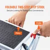 Close-up view of hands interacting with a foldable two-step stool, demonstrating its locking mechanism. Voir les images du produit