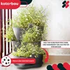 A stacked vertical planter filled with small white and yellow flowers, placed on a balcony or patio. Produktbild-Vorschau