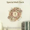 A wooden mechanical clock is displayed on a wall above a shelf with books. Voir les images du produit