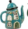 A close-up of a decorative teapot shaped like a house, with windows and a door. Produktbild-Vorschau