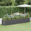 A raised garden bed filled with hydrangeas in a garden setting, with a table and chairs and an umbrella in the background. Produktbild-Vorschau