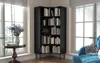 A black corner bookshelf filled with books is placed in a room with two large windows. A small round table with a vase of flowers is to the left of the bookshelf. Produktbild-Vorschau