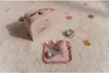 A children's tea set with a suitcase is laid out on a fluffy white carpet. Anteprima dell’immagine prodotto