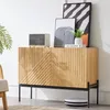 A wooden sideboard with black metal legs, decorated with artwork and a speaker, in a room setting. Anteprima dell’immagine prodotto