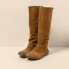 A pair of brown suede boots on a light-colored surface. Voir les images du produit