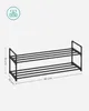 A black, two-tiered shoe rack with dimensions indicated. Náhled obrázku produktu
