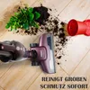 A vacuum cleaner is shown on a wooden floor next to spilled soil and a plant. Produktbild-Vorschau
