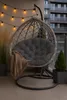 A hanging egg chair with a cushion and blanket on a balcony, decorated with string lights. Produktbild-Vorschau