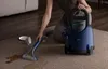 A person is using a carpet cleaner to clean a spill on a carpet. Anteprima dell’immagine prodotto