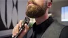 A man is trimming his beard with an electric trimmer. Náhled obrázku produktu