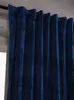 A close-up view of dark blue velvet curtains hanging from a curtain rod. Produktbild-Vorschau