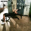 A man is performing a weightlifting exercise on a bench press in a gym. Produktbild-Vorschau