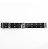 A black belt with silver grommets and a silver buckle is laid out horizontally against a white background. Anteprima dell’immagine prodotto