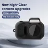 A small black digital camera is displayed on a white platform with a light gray textured background. Text overlays highlight features. Produktbild-Vorschau