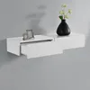 A white floating shelf with a drawer pulled out, decorated with two picture frames and a black vase with flowers. Voir les images du produit