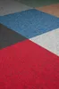 A close-up view of a carpet tile with a geometric pattern. Produktbild-Vorschau