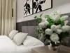 A bedroom scene with a bed, pillows, artwork, and a vase of flowers. Produktbild-Vorschau