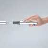 A hand is shown holding a chrome faucet with a black grip. Produktbild-Vorschau